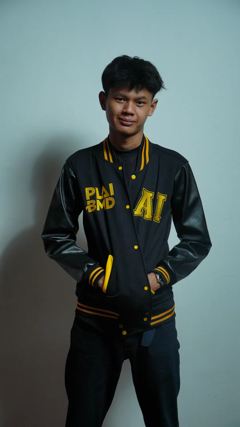 Juansyah Nursedam in a black varsity jacket with gold trim.